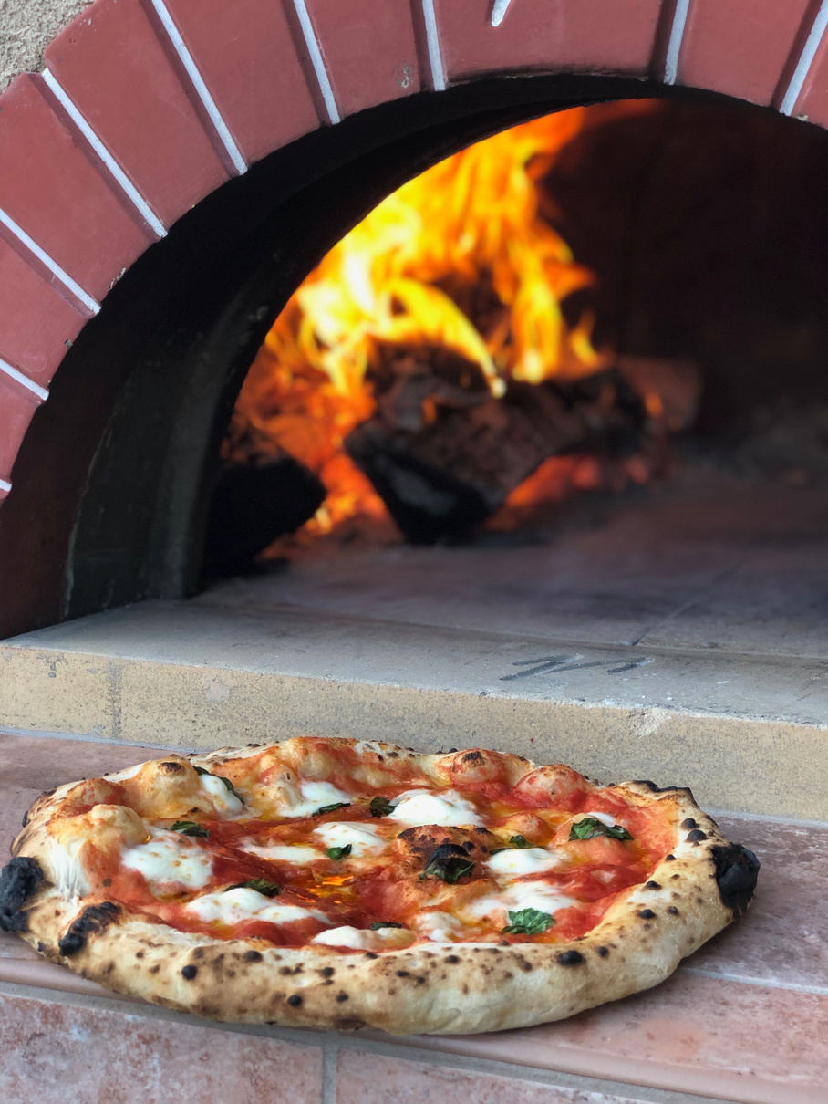 a pizza sitting on top of a brick oven
