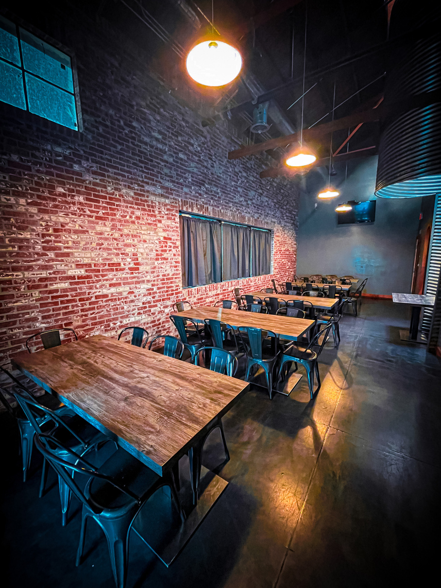 a restaurant with tables and chairs in front of a brick wall (no gender, age, or ethnicity information present)